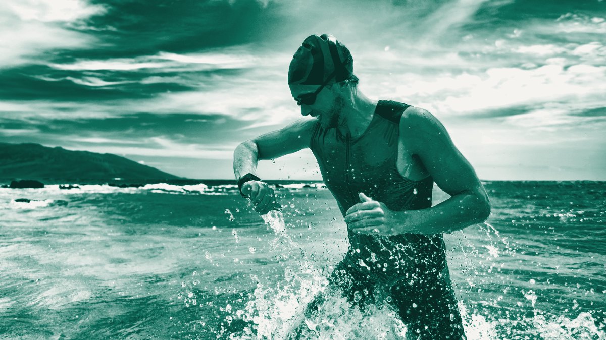 Schwimmer verlässt das Wasser und schaut auf die Uhr